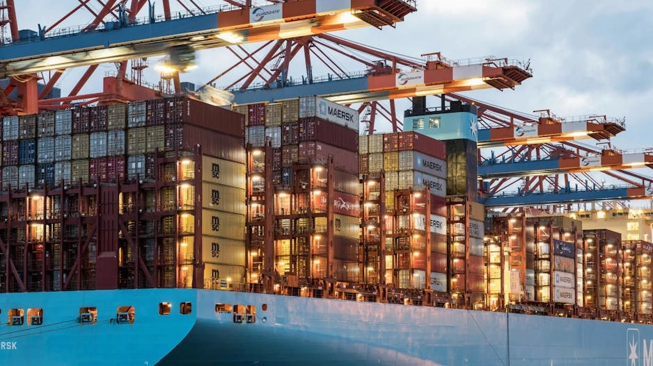 Spazio di lavoro creativo con mappe del mondo e campioni di packaging ecologico.